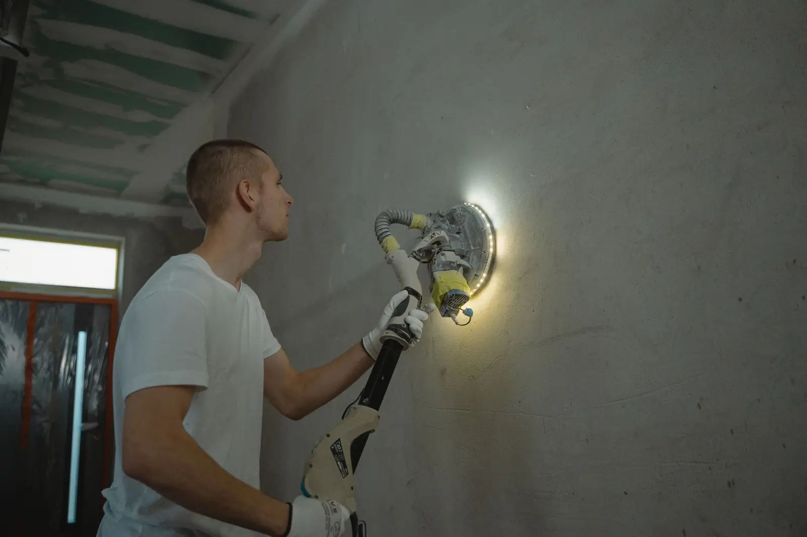Artisan ponçant un mur fraîchement enduit