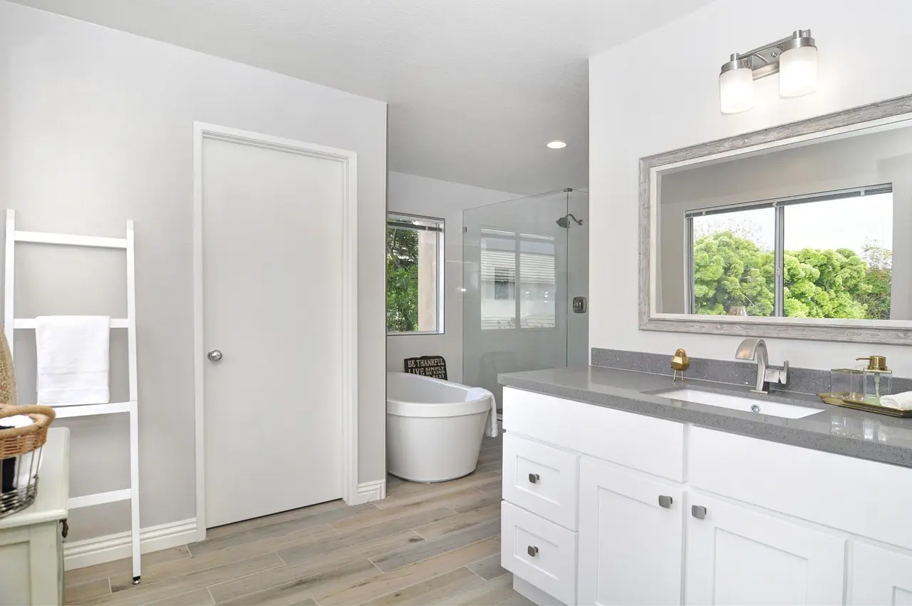 Salle de bain rénovée avec baignoire et meuble vasque blanc